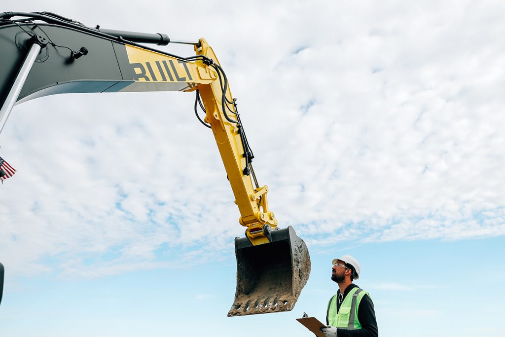 construction worker looking at automated robotic construction machinery