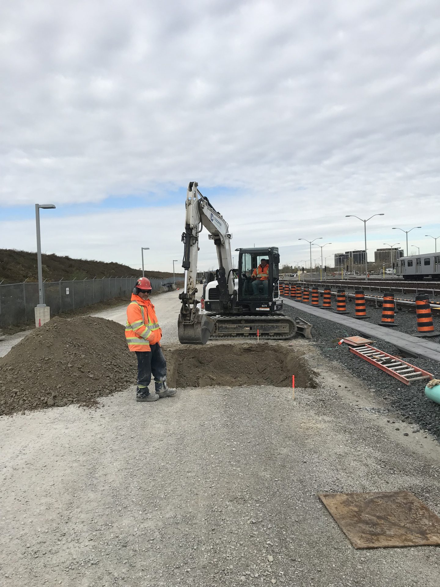 Clearway construction worker in front of excavator