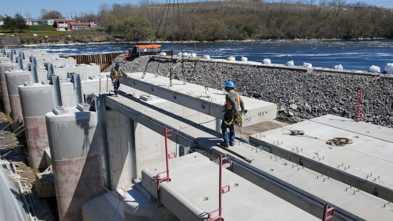 construction workers laying concrete dam