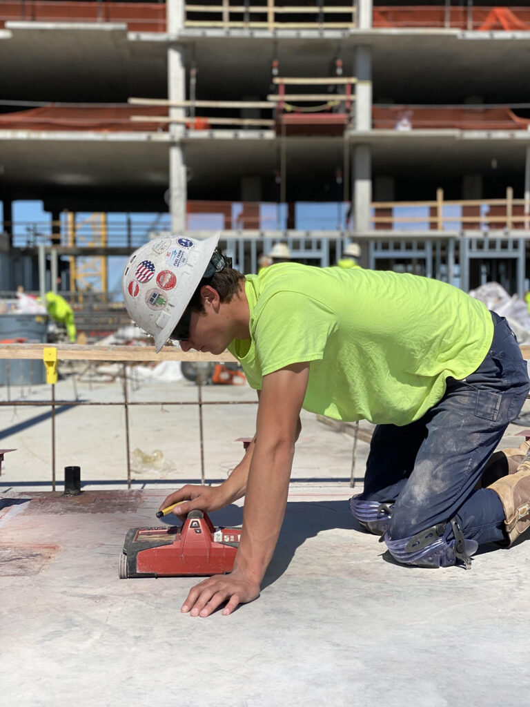 construction worker working on knees on concrete slab