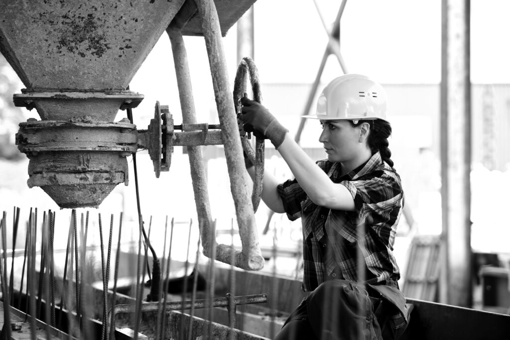 female construction worker using cement machinery