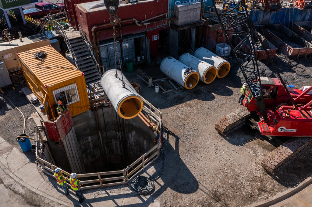 tehcnicore underground lowering pipe into tunnel