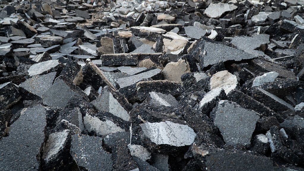 Background old cracked asphalt road scrap heap damage on the ground to be recycled.