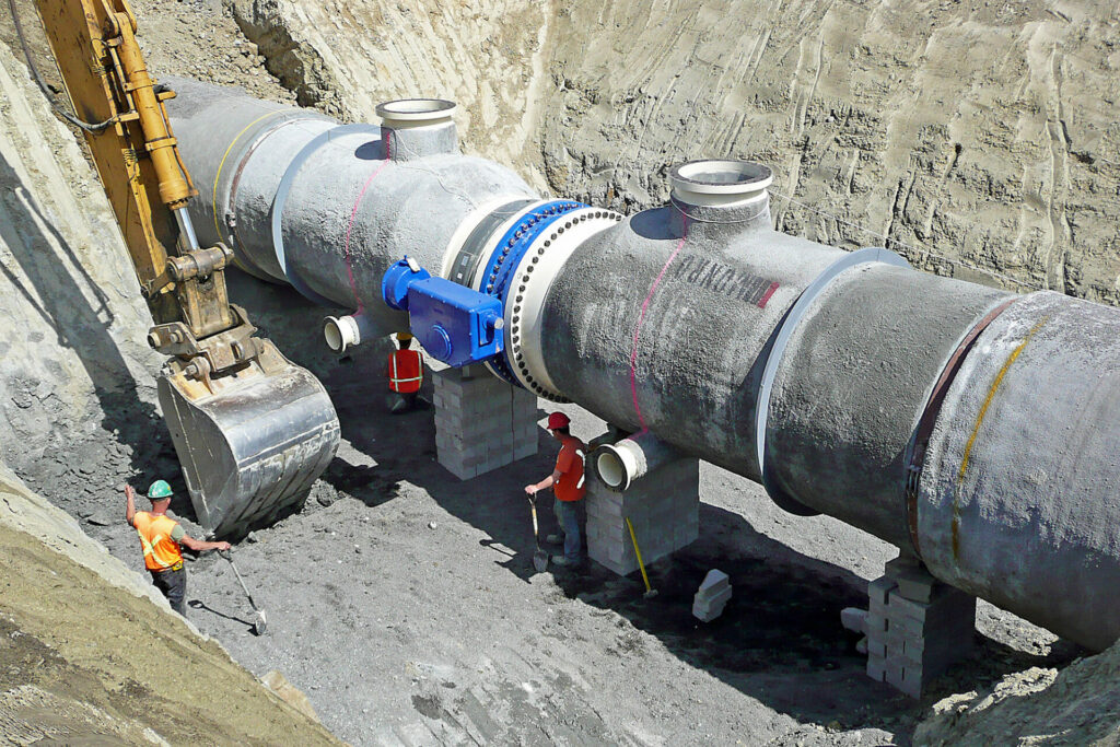 ACPPA workers next to large concrete pipe construction site