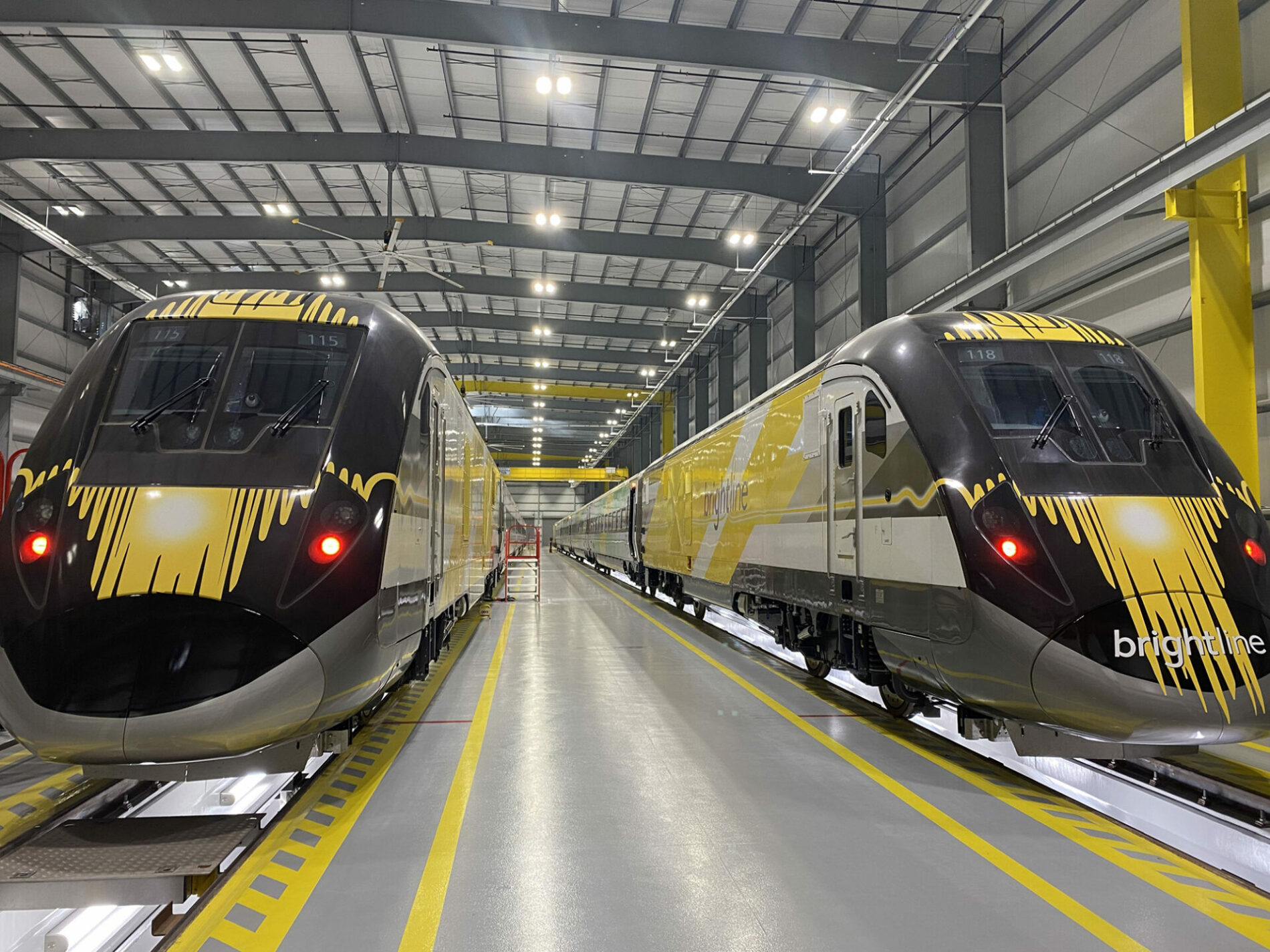 Two subway trains parked in warehouse.