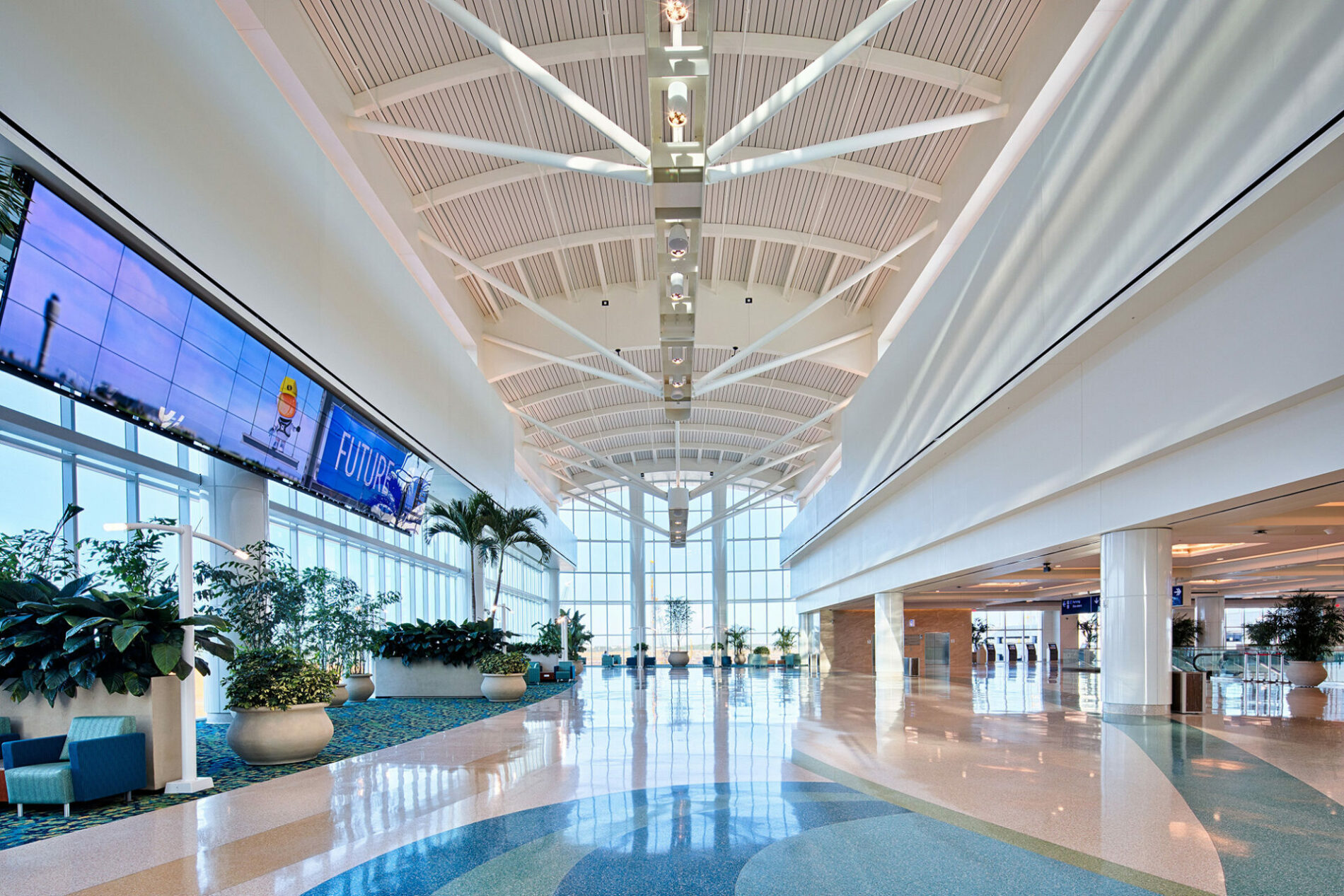 The interior of an airport, high ceilings and bright lights.