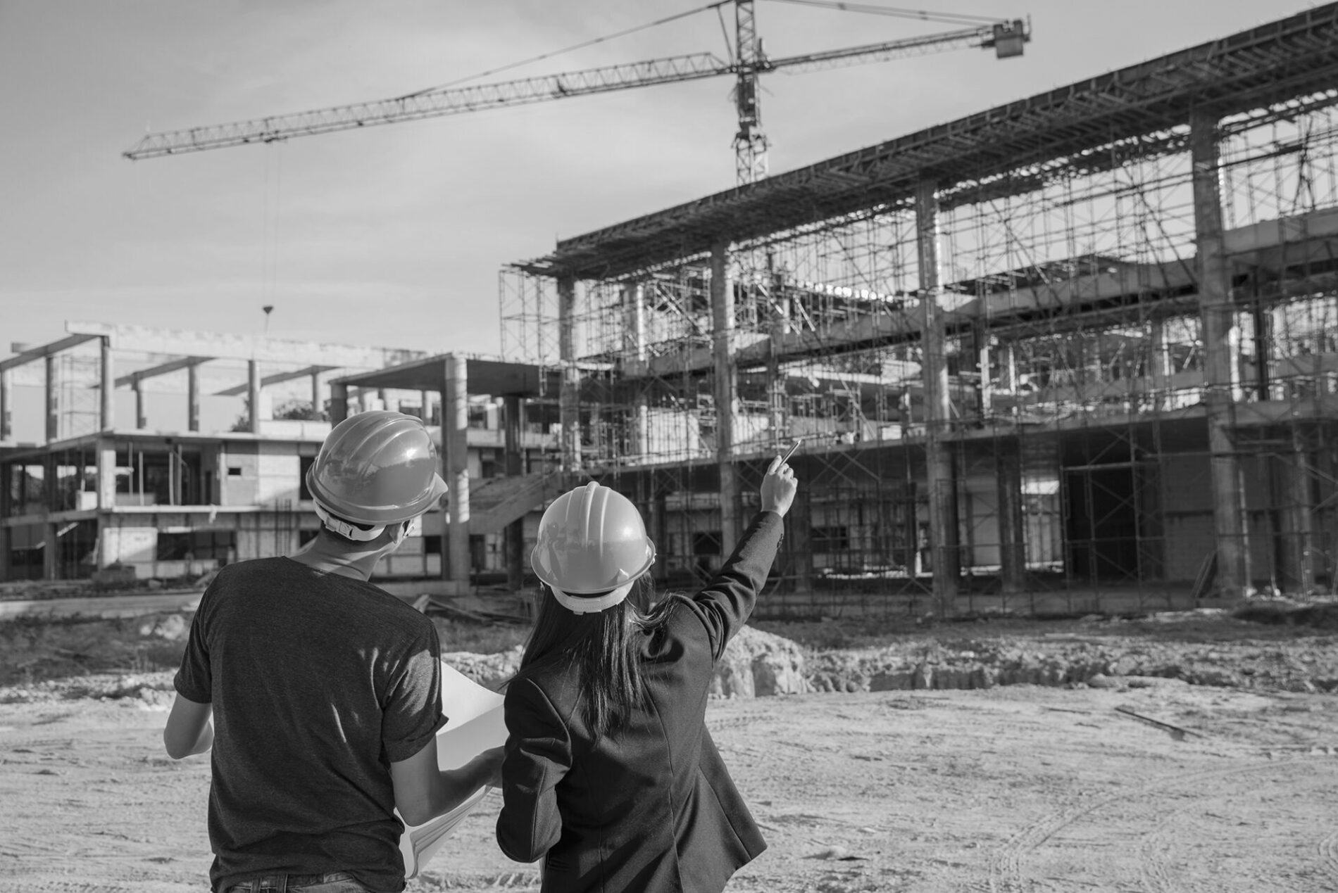 Professional Construction woman engineer Manager wear safety yellow helmet discuss with worker pointing at Blueprint serious at building project with better structures.Construction Engineer concept.