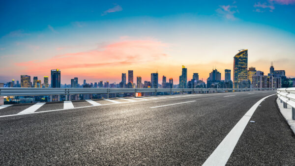 Empty asphalt road and city skyline with buildings at sunset in Shanghai.