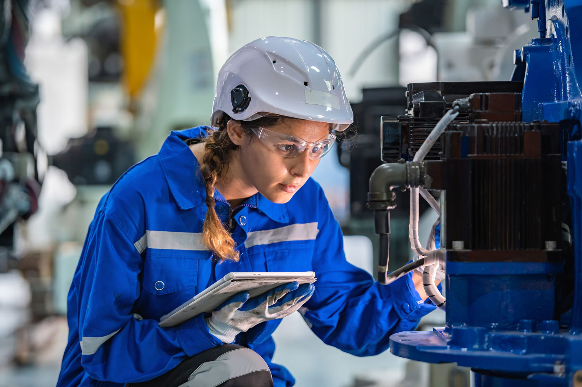 woman engineer in uniform helmet inspection check control heavy machine robot arm construction installation in industrial factory. technician worker check for repair maintenance electronic operation