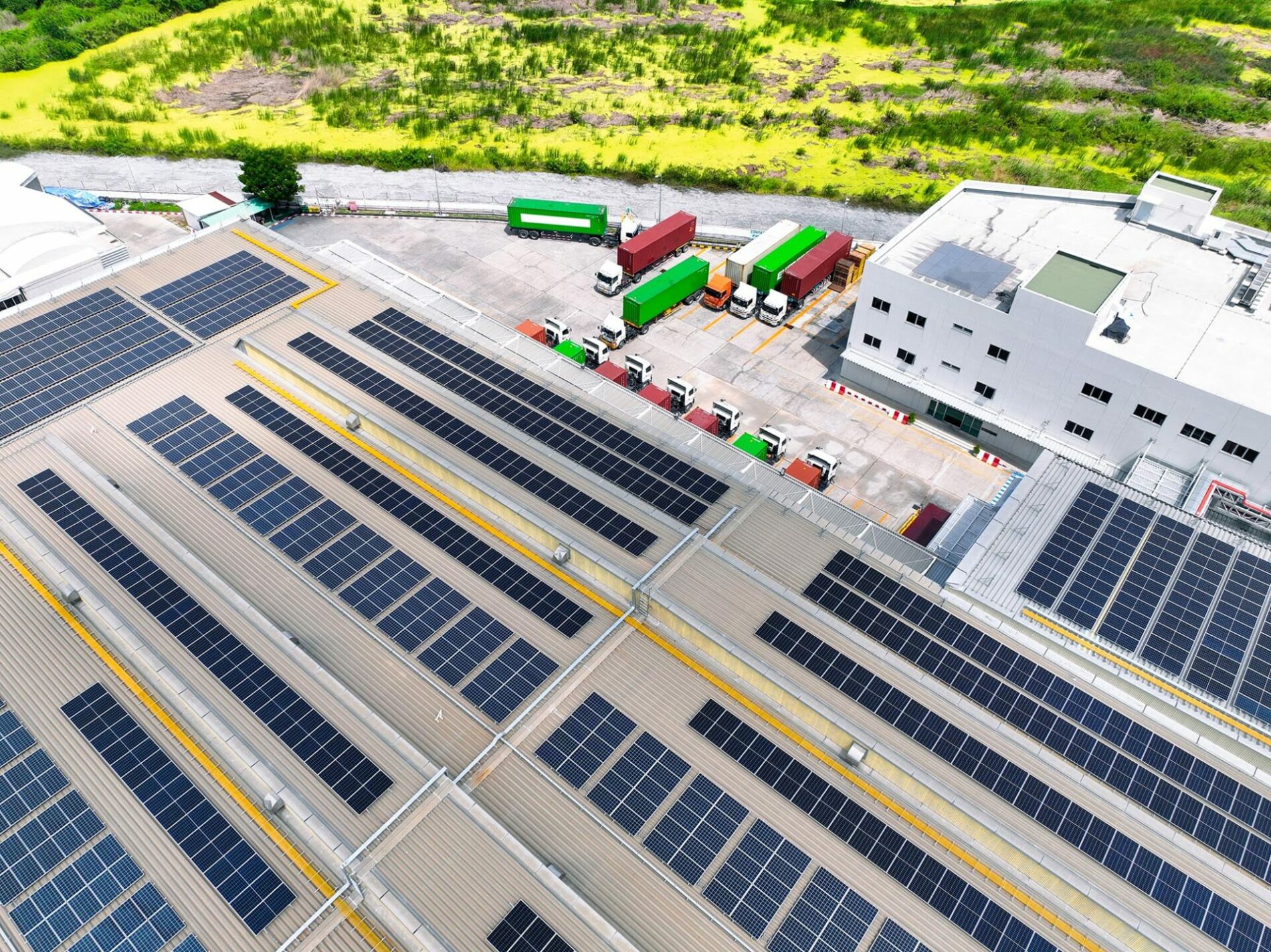 Solar-powered warehouse facility with freight trucks at loading docks. Eco-friendly logistics and efficient cargo transportation. Solar panels and sustainable energy concept in distribution center.